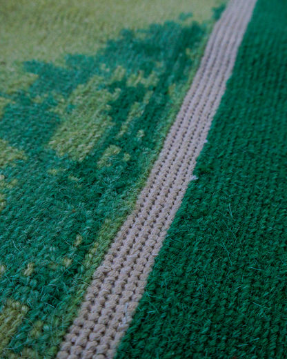 Macro detail of the white pitch line and hand knotted green pile
